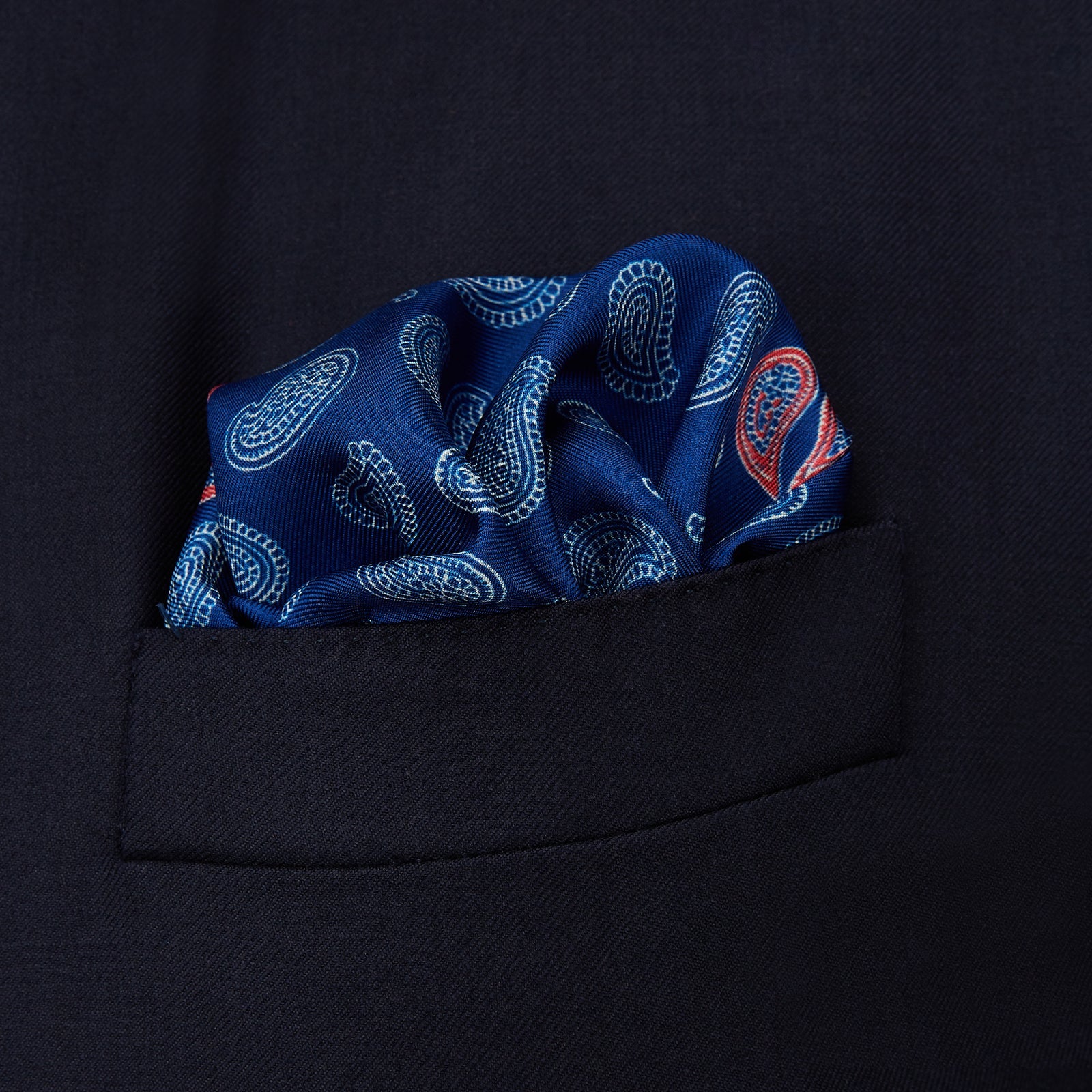 View 2 of product The Navy Multi Valentines Day Special Silk Pocket Square from Turnbull & Asser features a blue base with white and pink paisley motifs, a decorative border, and a discreet logo—an elegant gift for Valentine’s Day.