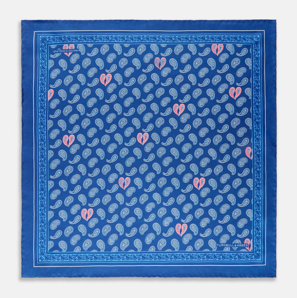 The Navy Multi Valentines Day Special Silk Pocket Square from Turnbull & Asser features a blue base with white and pink paisley motifs, a decorative border, and a discreet logo—an elegant gift for Valentine’s Day.