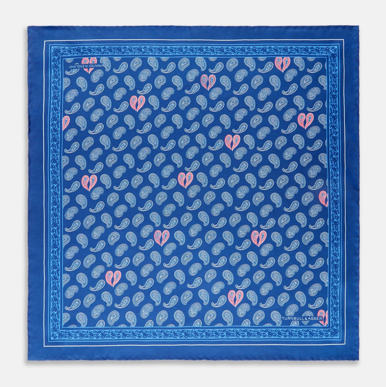 View 1 of product The Navy Multi Valentines Day Special Silk Pocket Square from Turnbull & Asser features a blue base with white and pink paisley motifs, a decorative border, and a discreet logo—an elegant gift for Valentine’s Day.