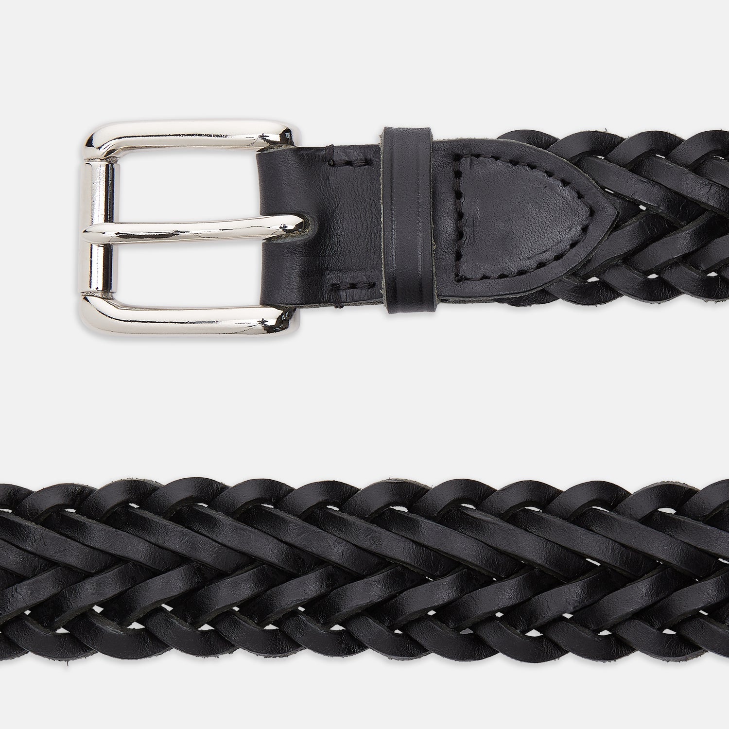 View 2 of product The Turnbull & Asser Black Leather Woven Belt, hand-woven with a shiny silver buckle, is shown rolled up on a plain white background.