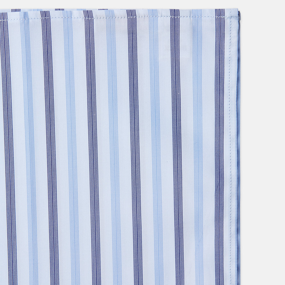 The Turnbull & Asser Blue Multi Stripe Cotton Handkerchief is shown flat against a white background, with one corner folded to reveal its reverse side. It features horizontal and vertical blue and white stripes on luxury cotton.