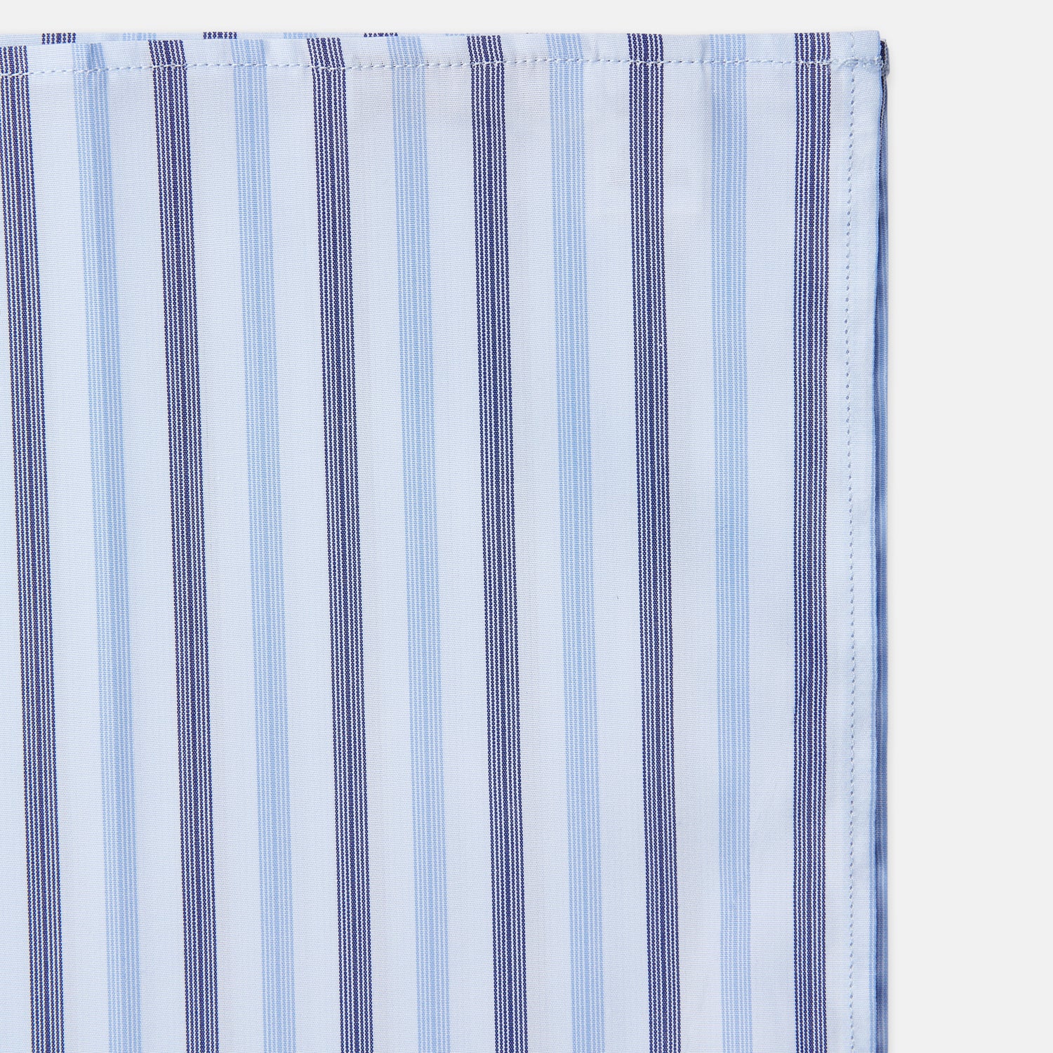 View 3 of product The Turnbull & Asser Blue Multi Stripe Cotton Handkerchief is shown flat against a white background, with one corner folded to reveal its reverse side. It features horizontal and vertical blue and white stripes on luxury cotton.