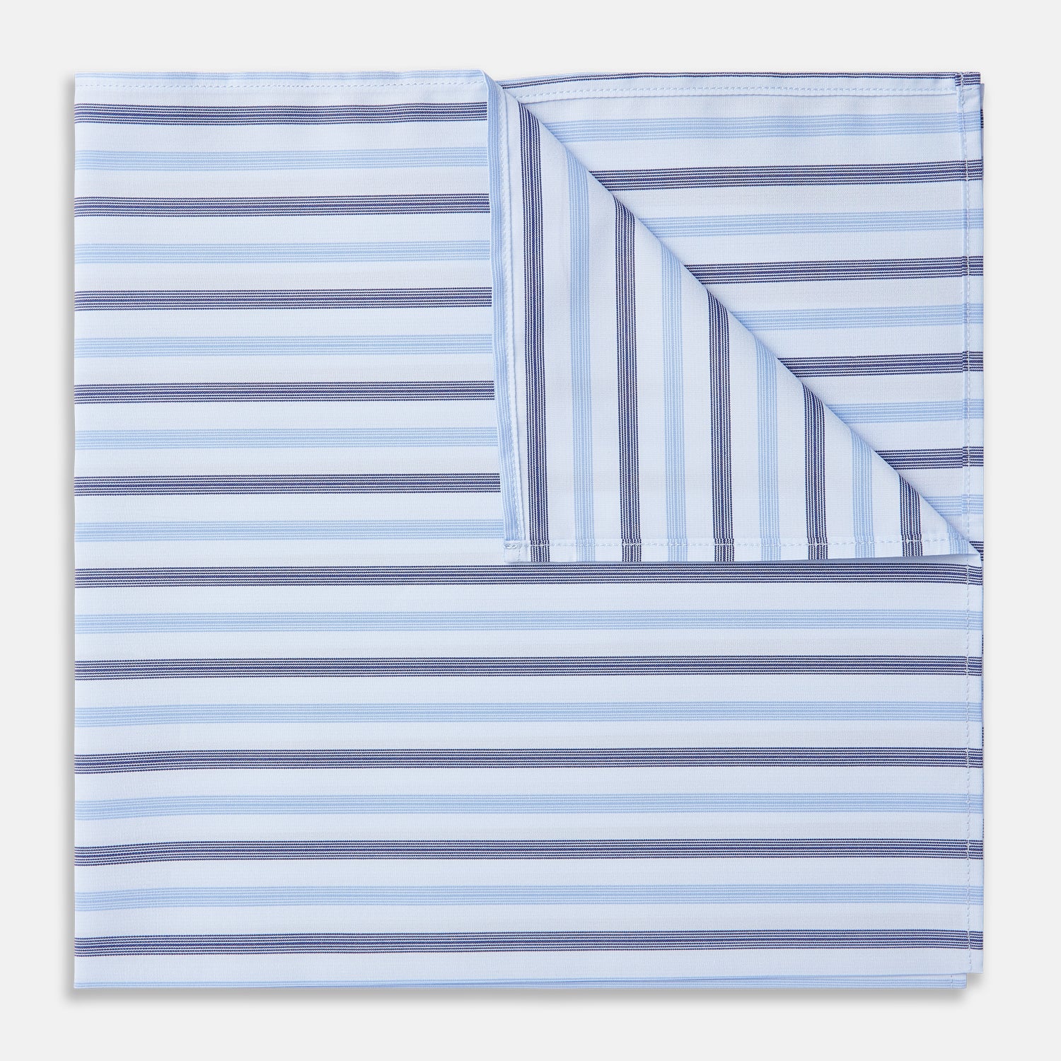 View 1 of product The Turnbull & Asser Blue Multi Stripe Cotton Handkerchief is shown flat against a white background, with one corner folded to reveal its reverse side. It features horizontal and vertical blue and white stripes on luxury cotton.