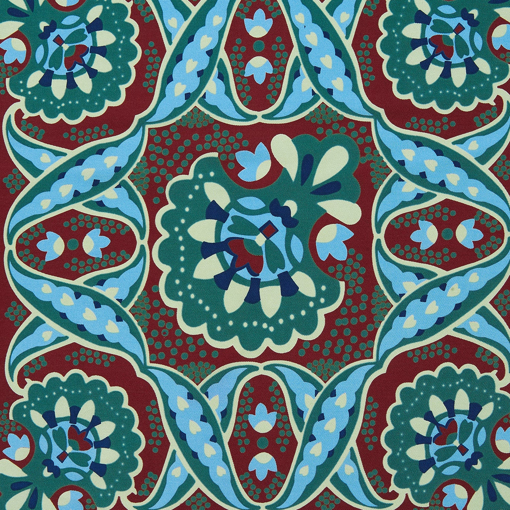 The Aqua and Burgundy Baroque Silk Pocket Square by Turnbull & Asser is crafted in England, featuring an intricate symmetrical pattern in teal, blue, red, and cream with ornate motifs framed by decorative borders.