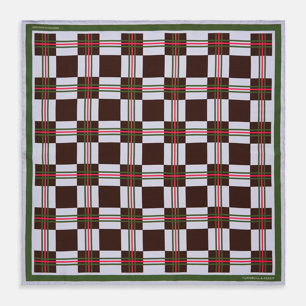 The Turnbull & Asser Green and Red Checked Chess Board Silk Pocket Square features brown, green, red, and white stripes with a thin green border and the brand's name in the bottom right corner.