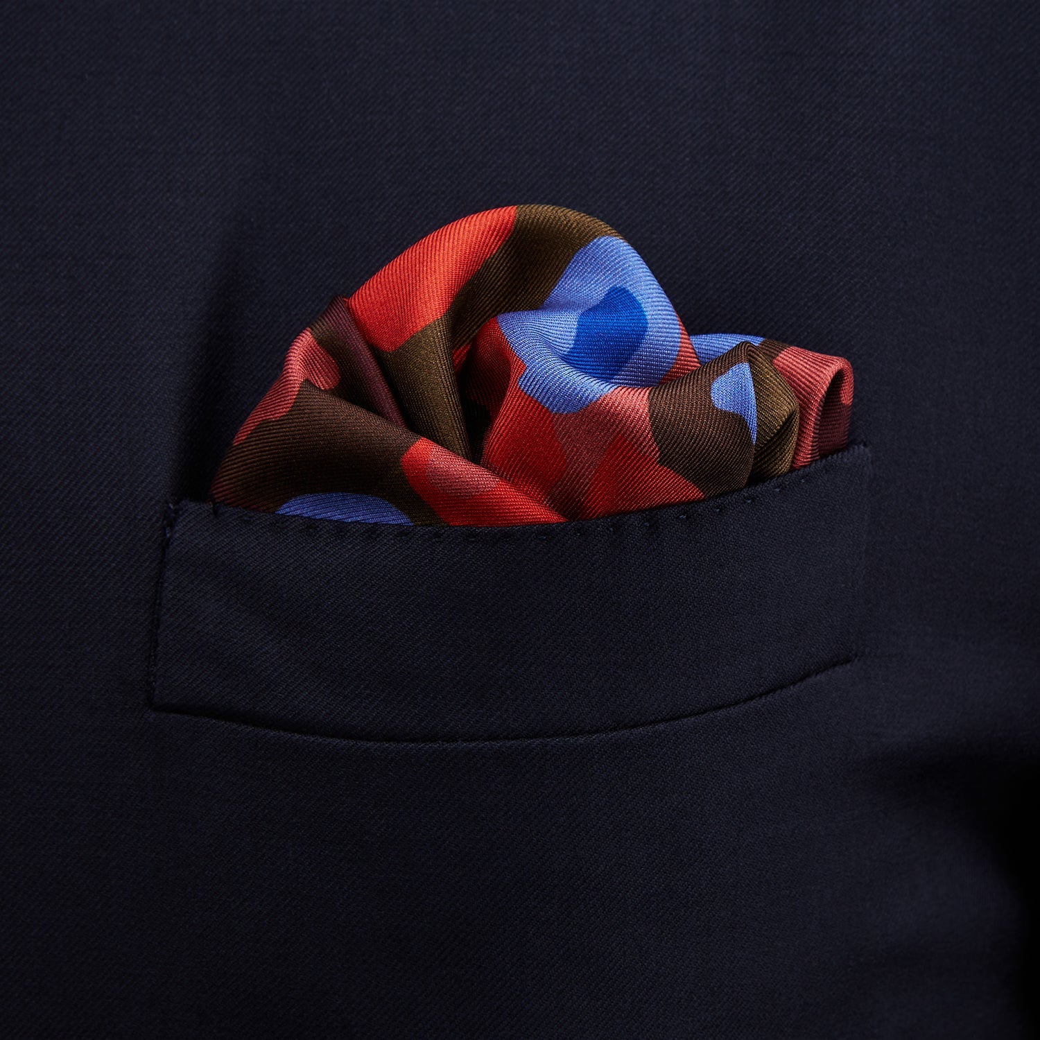 View 3 of product The Turnbull & Asser Green, Burgundy, and Pink Abstract Olives Silk Pocket Square features an abstract olive pattern with bold colors, a border, and corner text. Made in England.