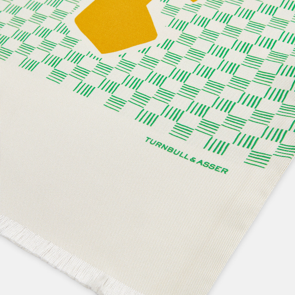 The Gold and Green Abstract Bird Silk Lawton Scarf by Turnbull & Asser features a white base with green checks, bold yellow Cubism-inspired bird motifs, and fringed edges, elegantly draped against a white background.