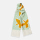 The Gold and Green Abstract Bird Silk Lawton Scarf by Turnbull & Asser features a white base with green checks, bold yellow Cubism-inspired bird motifs, and fringed edges, elegantly draped against a white background.
