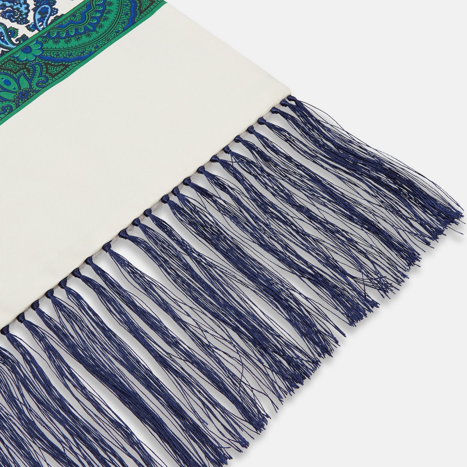 View 2 of product The Turnbull & Asser Green and Blue Paisley Silk Scarf features a blue and green paisley print on white, a solid cream section, a green stripe, and navy fringed ends.