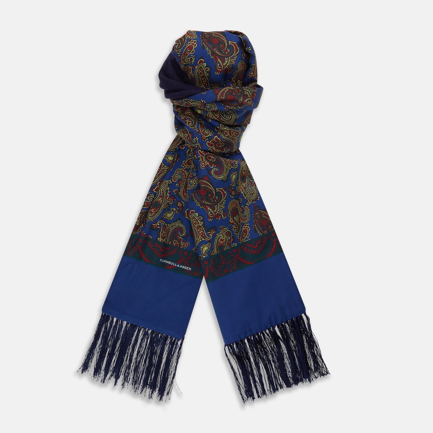 View 1 of product A sophisticated accessory, the Turnbull & Asser Burgundy and Ivy Paisley Silk Scarf features an intricate paisley pattern and solid ends with blue fringed tassels, displayed against a white background.