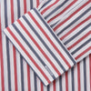 View 4 of product The Turnbull & Asser Red and Blue Stripe Cotton Regular Fit Whitby Shirt is a long-sleeve button-up featuring vibrant red and blue stripes on white, with a collar and buttoned cuffs, shown on a plain white surface.