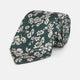 The Turnbull & Asser Dark Green Floral Garden Silk Tie features an elegant white floral pattern on dark green silk, shown rolled against a plain white background.