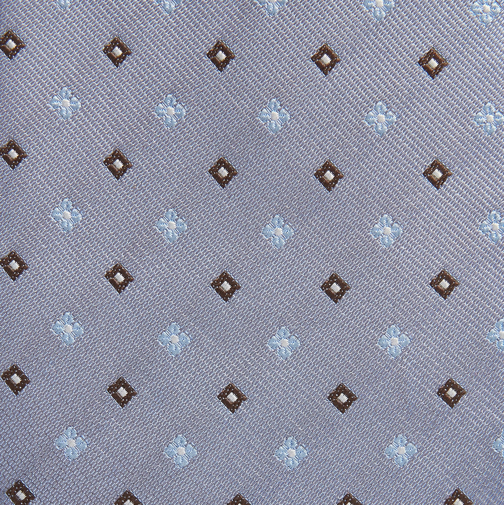 The Pale Blue Multi Floret Silk Tie by Turnbull & Asser features light purple silk with a pale blue floret pattern and small brown squares—perfect for pairing with a classic Turnbull & Asser shirt.