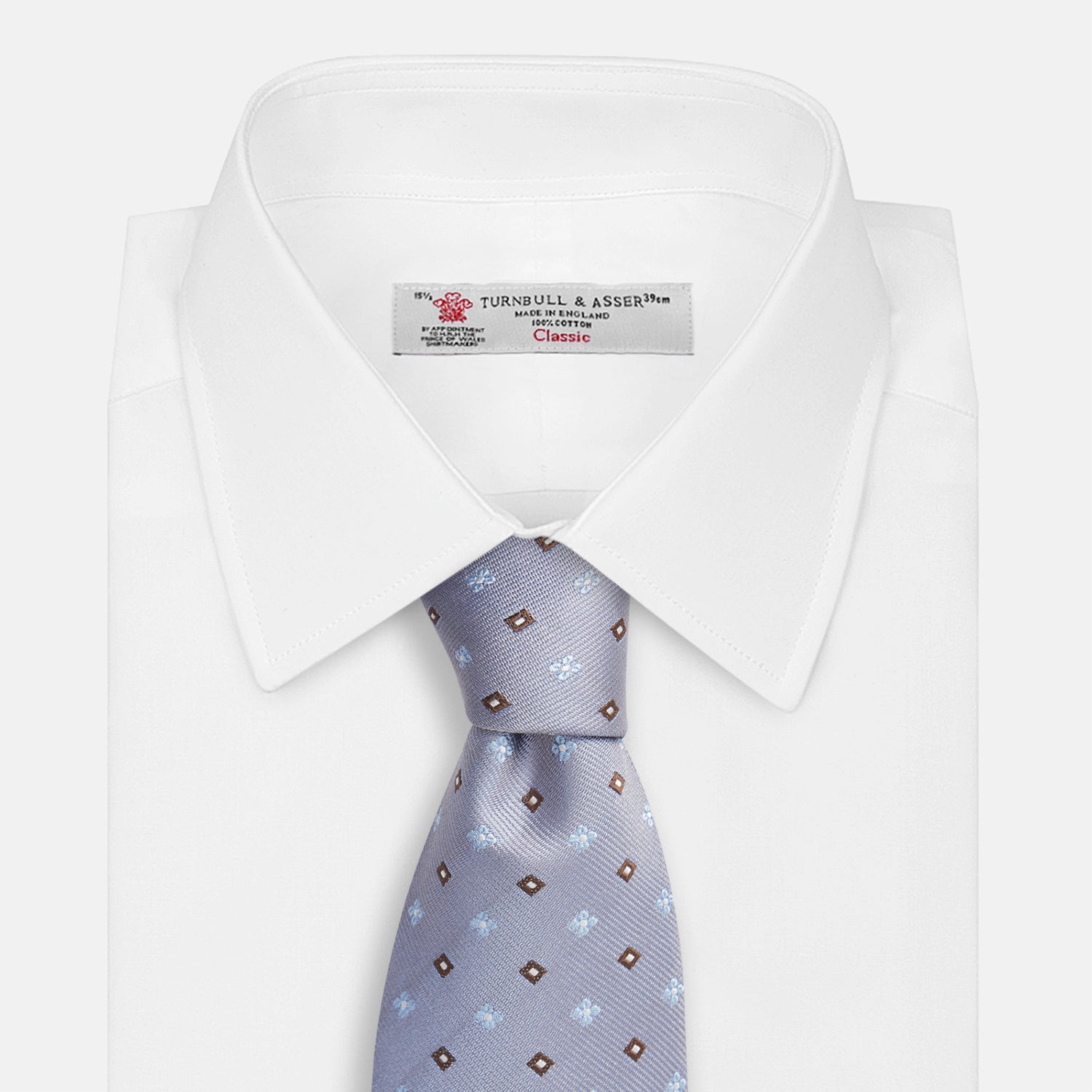 View 4 of product The Pale Blue Multi Floret Silk Tie by Turnbull & Asser features light purple silk with a pale blue floret pattern and small brown squares—perfect for pairing with a classic Turnbull & Asser shirt.