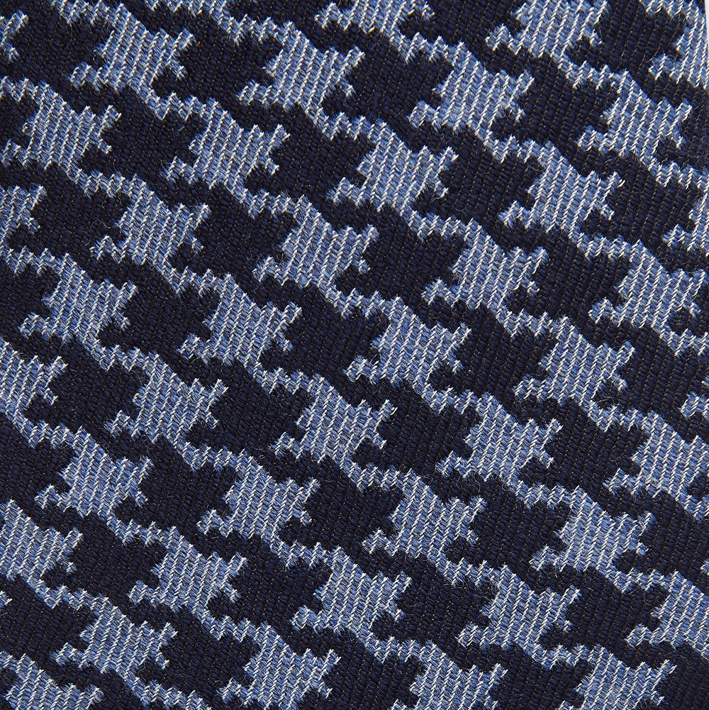The Turnbull & Asser Navy and Blue Houndstooth Wool Blend Tie features a stylish houndstooth pattern in navy and light blue.