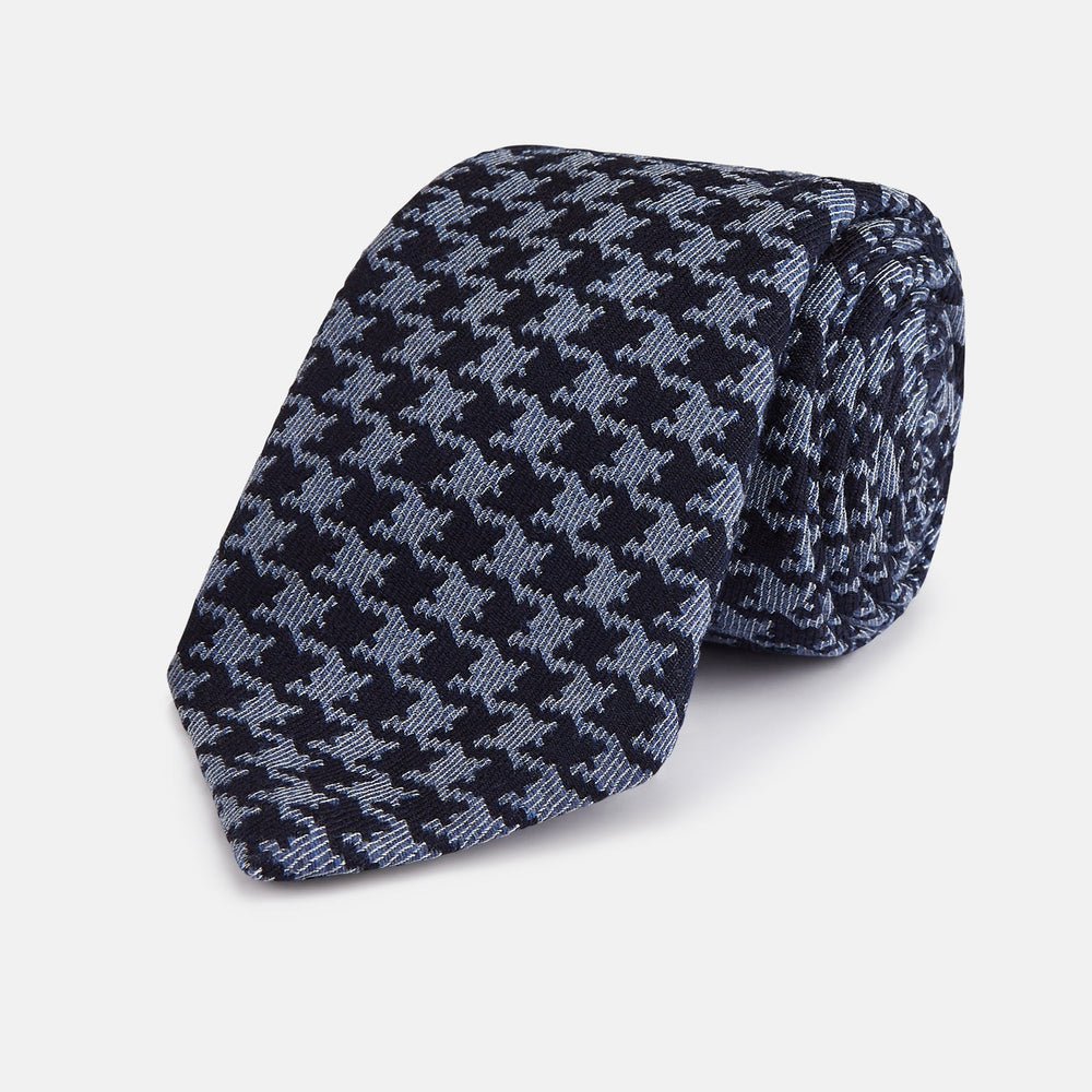 The Turnbull & Asser Navy and Blue Houndstooth Wool Blend Tie features a stylish houndstooth pattern in navy and light blue.