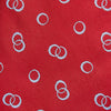 View 2 of product The Turnbull & Asser Red Geometric Rings Silk Tie, made in England, features a rolled-up design with small overlapping light blue circles on red silk and is displayed against a plain white background.