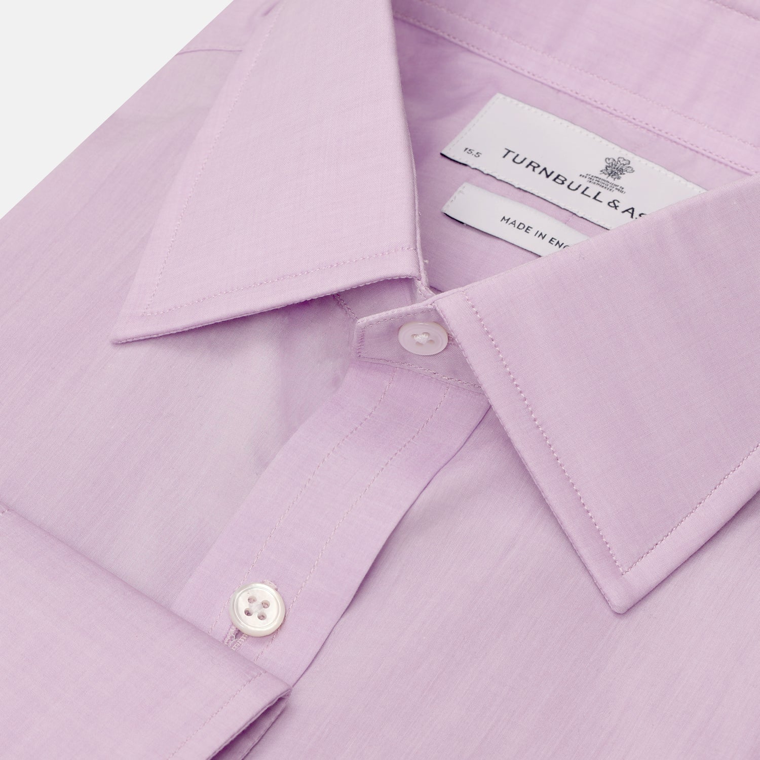 View 2 of product The Turnbull & Asser LILAC COTTON REGULAR FIT SHIRT is a long-sleeve, button-up cotton shirt with white buttons, a classic T&A collar, and cuffs, shown laid flat on a white background.