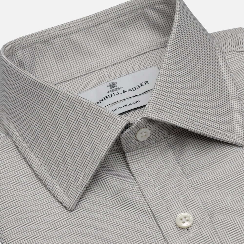 The Turnbull & Asser Silver Multi-Check Cotton Regular Fit Shirt features light gray cotton, a classic collar, buttoned cuffs, and a subtle silver check pattern—an essential for any men's wardrobe, shown flat on a white background.