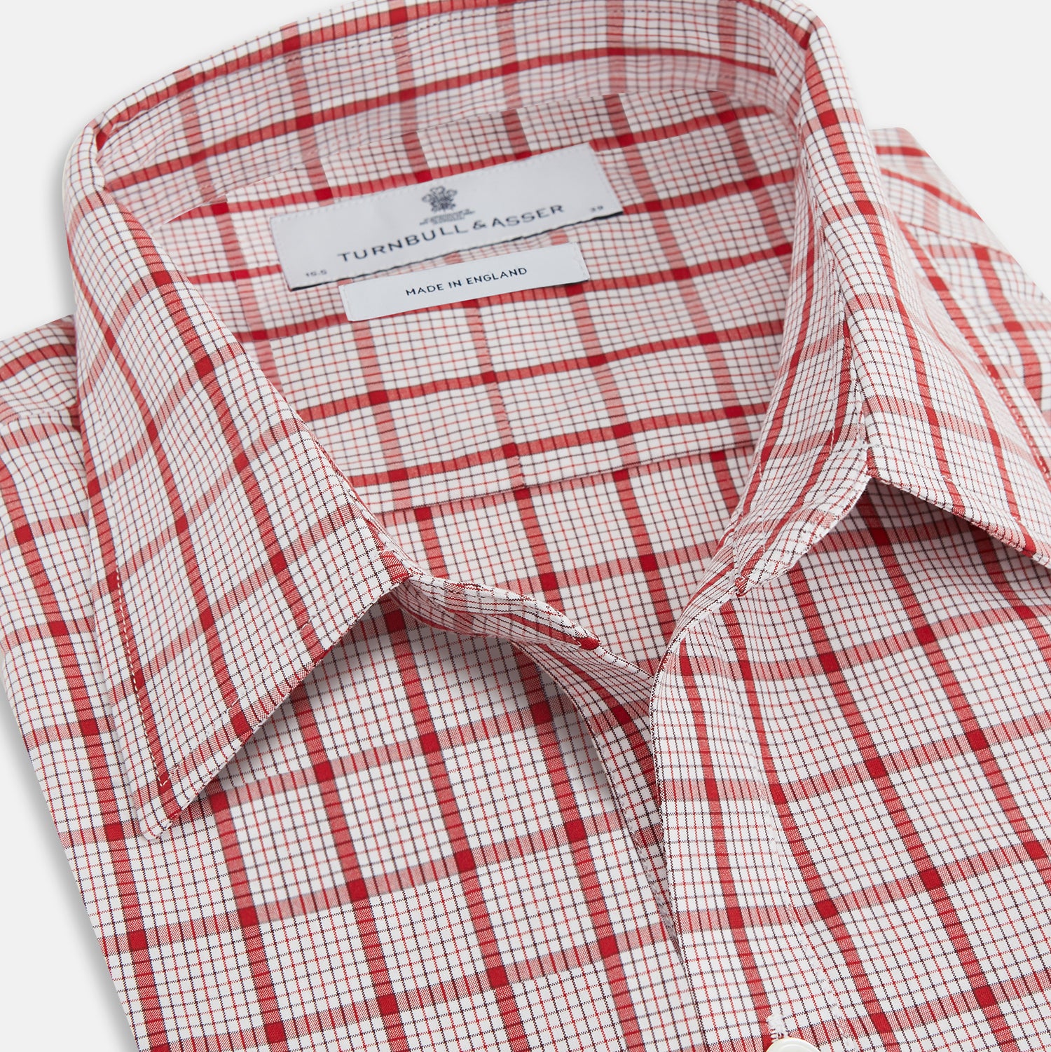 View 2 of product The Turnbull & Asser Red Graph Overlay Check Piccadilly Shirt is a cotton, long-sleeve button-up with a white base, red graph check pattern, collar, two chest flap pockets, and white buttons on the front and cuffs.