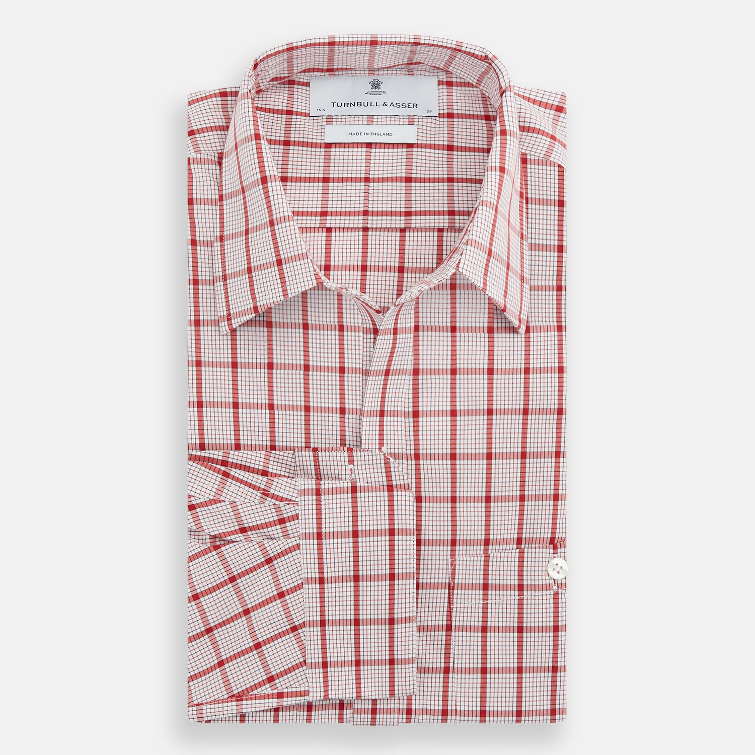 View 5 of product The Turnbull & Asser Red Graph Overlay Check Piccadilly Shirt is a cotton, long-sleeve button-up with a white base, red graph check pattern, collar, two chest flap pockets, and white buttons on the front and cuffs.
