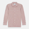 View 1 of product The Turnbull & Asser Red Graph Overlay Check Piccadilly Shirt is a cotton, long-sleeve button-up with a white base, red graph check pattern, collar, two chest flap pockets, and white buttons on the front and cuffs.