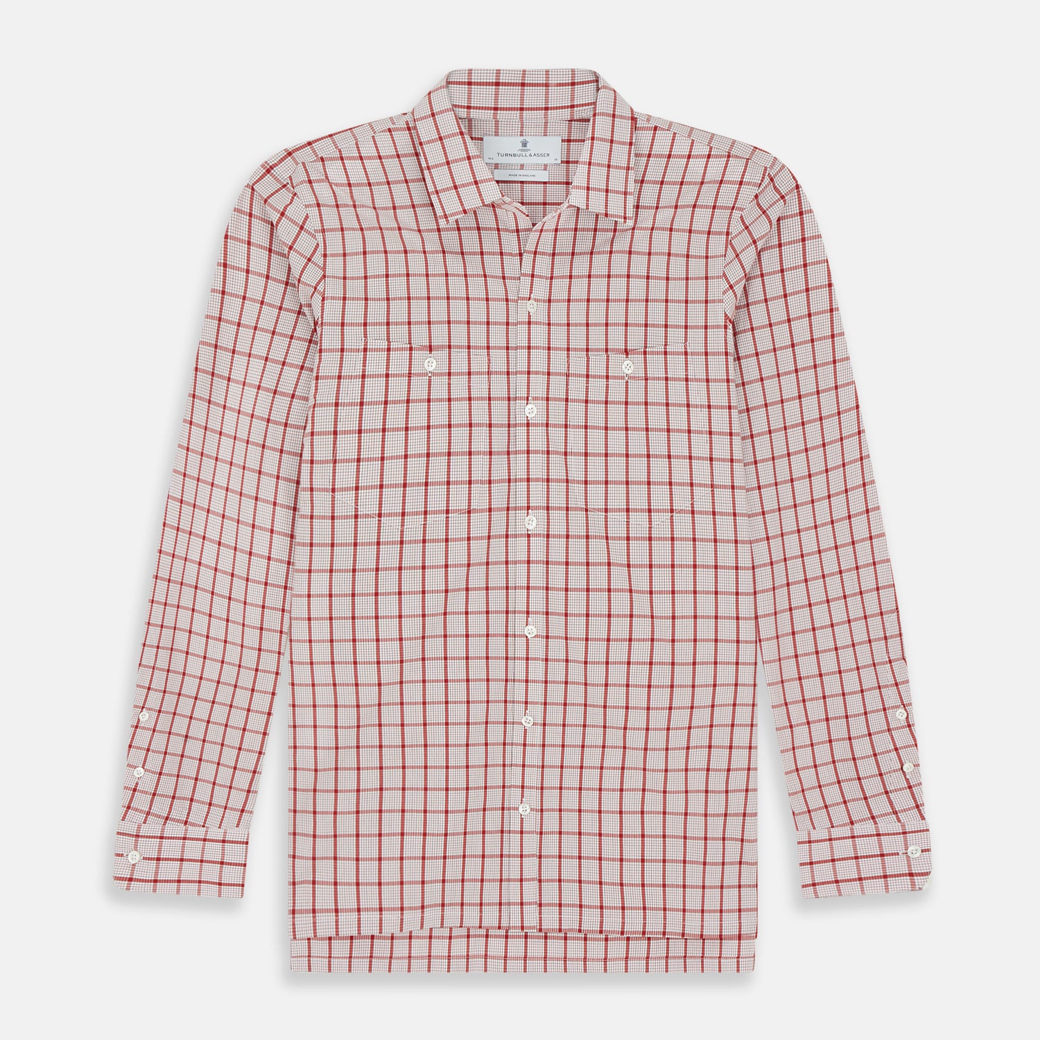 View 1 of product The Turnbull & Asser Red Graph Overlay Check Piccadilly Shirt is a cotton, long-sleeve button-up with a white base, red graph check pattern, collar, two chest flap pockets, and white buttons on the front and cuffs.