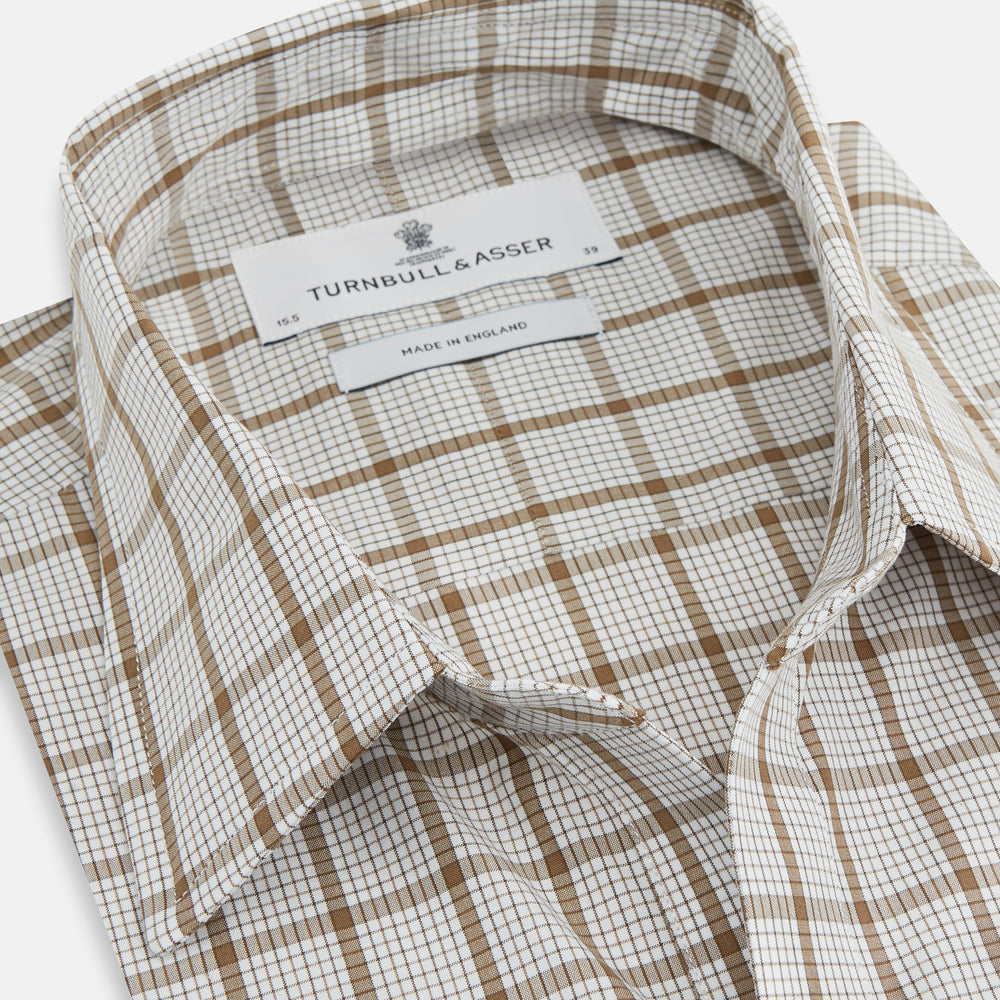 The Turnbull & Asser Brown Graph Overlay Check Piccadilly Shirt is a breathable cotton long-sleeve button-up with two chest pockets, in a beige and brown check pattern—ideal as your holiday fit shirt.