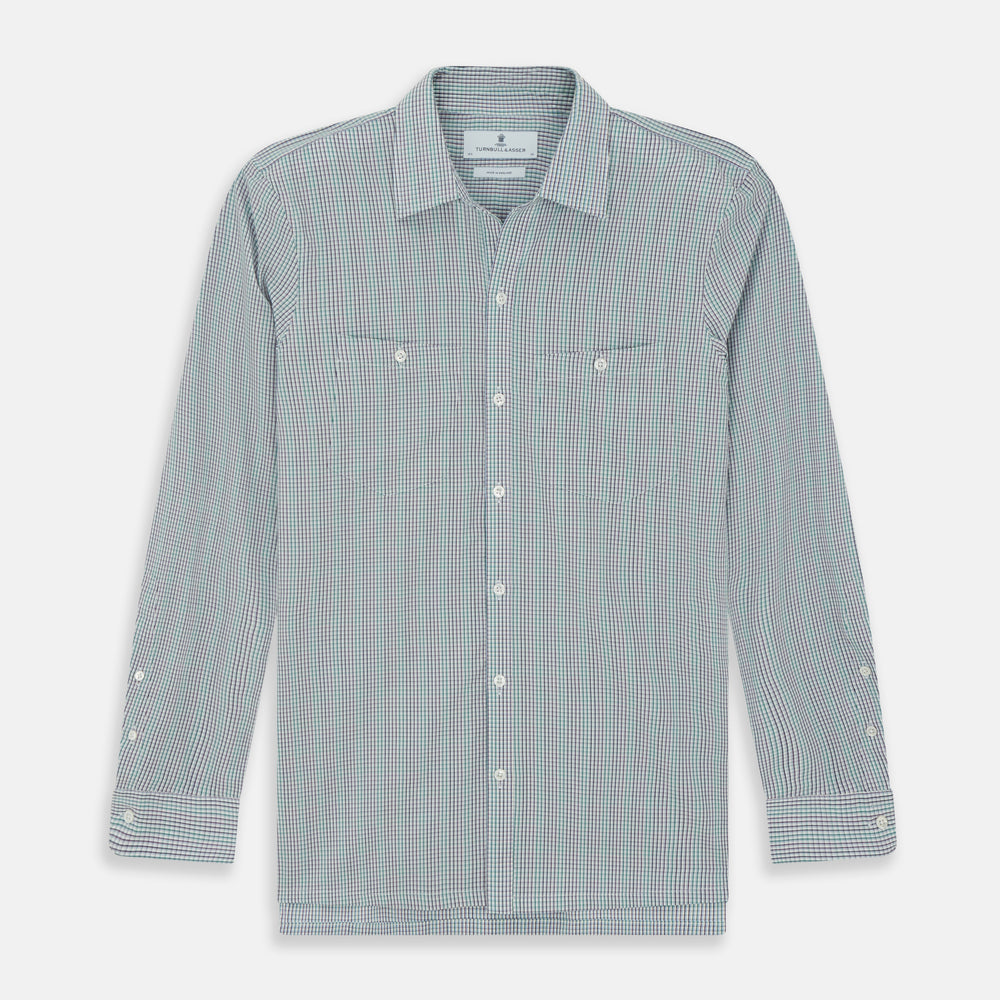 The Turnbull & Asser Green Graph Overlay Micro Check Piccadilly Shirt is a breathable cotton, long-sleeve button-up featuring a green micro check in light blue and white, two chest pockets with buttoned flaps, and white buttons.