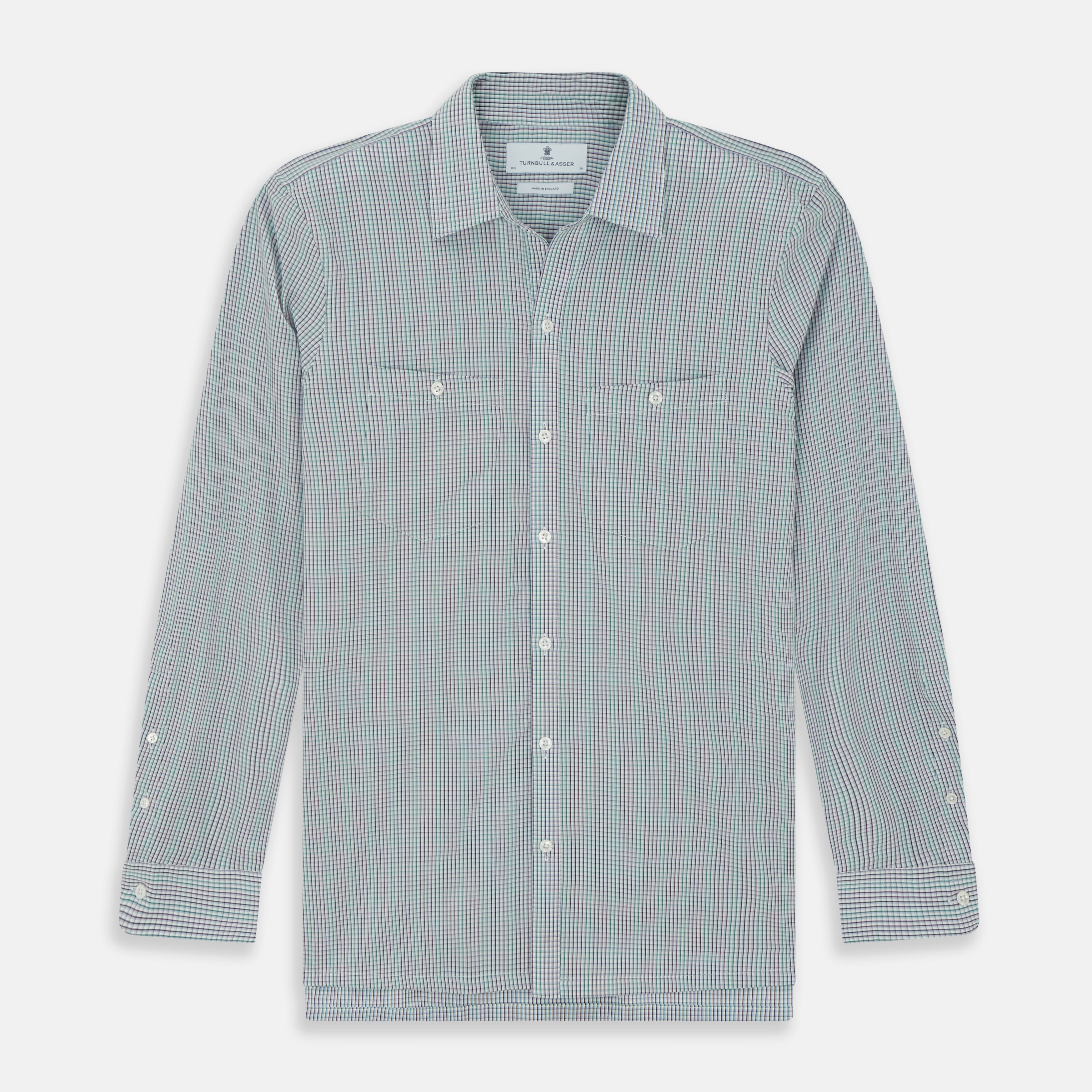 View 1 of product The Turnbull & Asser Green Graph Overlay Micro Check Piccadilly Shirt is a breathable cotton, long-sleeve button-up featuring a green micro check in light blue and white, two chest pockets with buttoned flaps, and white buttons.