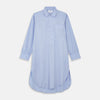 View 1 of product The Turnbull & Asser Blue Piped Sea Island Quality Cotton Nightshirt features light blue sea island cotton, a collared neckline with white piping, a front pocket, partial button placket, and a curved high-low hem for classic nightshirt style.
