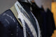 A Turnbull & Asser tailor's mannequin displays a partially finished shirt with visible stitching and a measuring tape, illustrating the Shirt alterations (Workrooms) service.