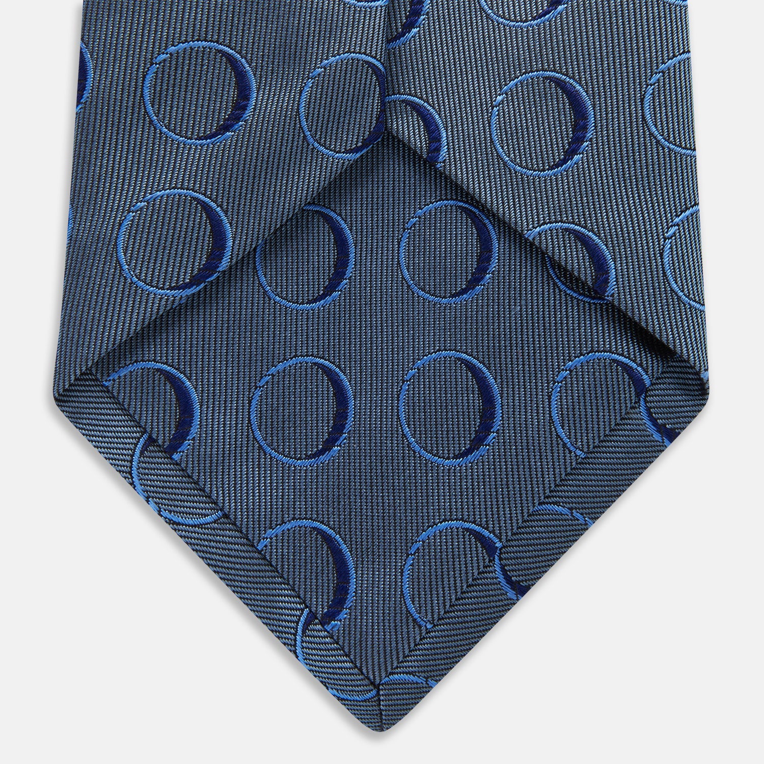 View 5 of product The Turnbull & Asser Die Another Day Circle Silk Tie, as seen on James Bond, features large dark blue ovals on a lighter blue background.