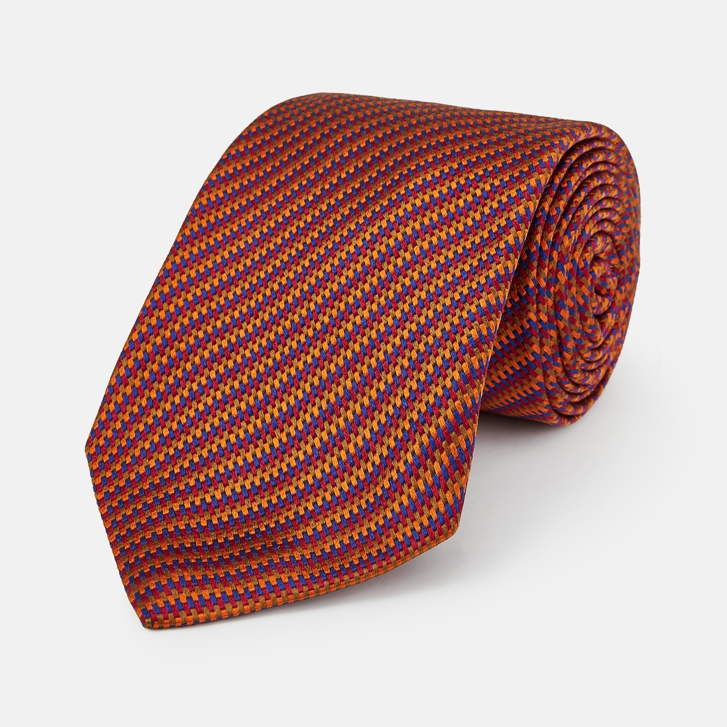 View 1 of product The Turnbull & Asser Die Another Day Stripe Silk Tie, as seen on James Bond, showcases a vibrant orange, red, and purple woven pattern, elegantly rolled and displayed against a white background.