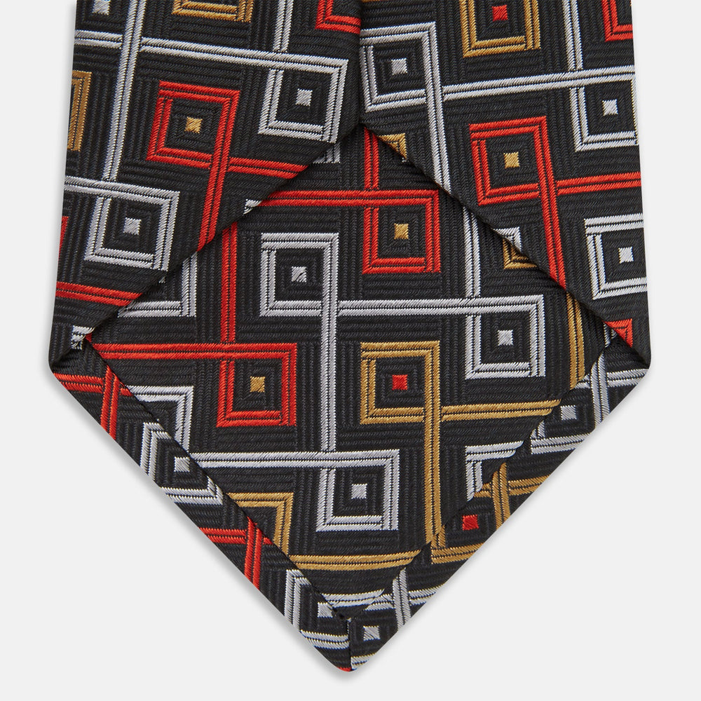 The Turnbull & Asser "The World Is Not Enough" Square Silk Tie, as seen on James Bond, features a geometric diamond pattern in black, red, yellow, and white on gray—an ideal stylish gift for any Bond fan.