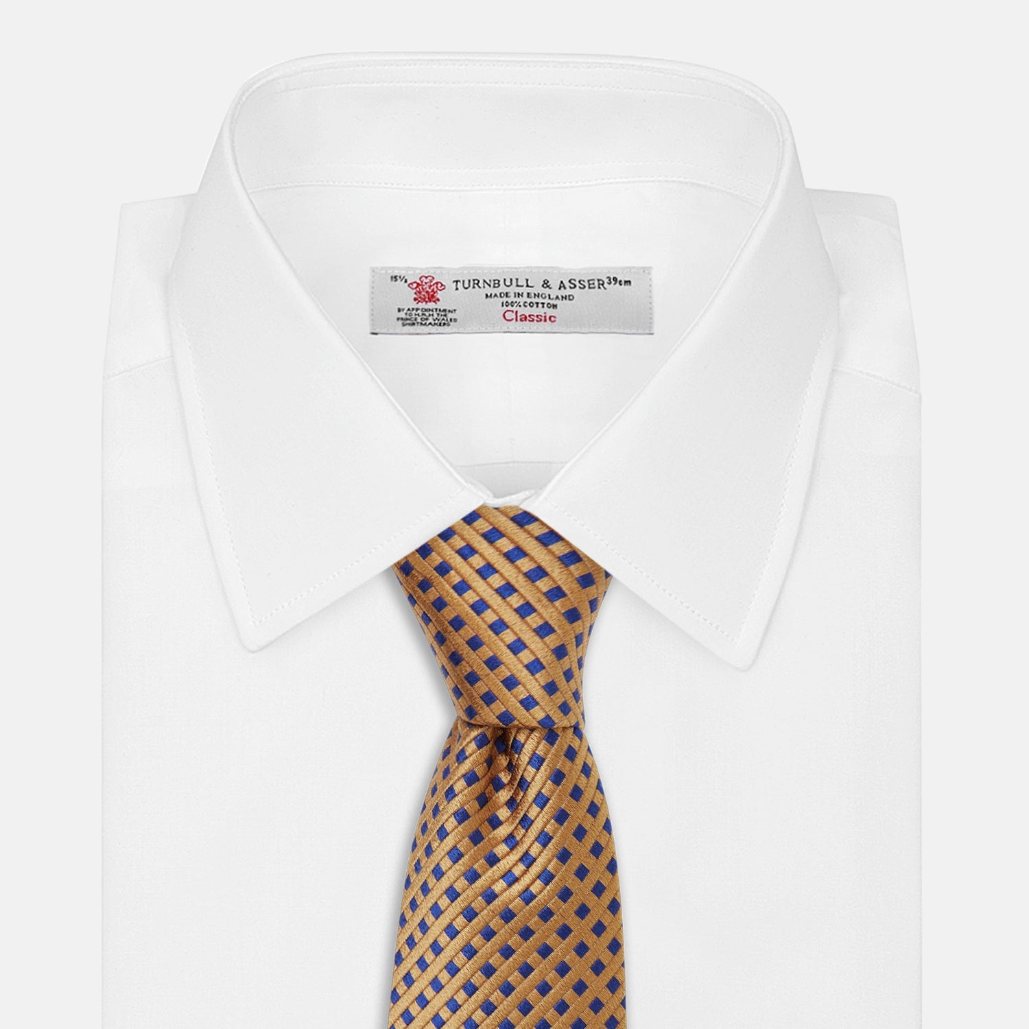 View 3 of product The Turnbull & Asser Tomorrow Never Dies Diamond Silk Tie, as seen on James Bond, features a gold and navy checkered pattern—an ideal gift for any Bond fan. Displayed rolled against a plain white background.