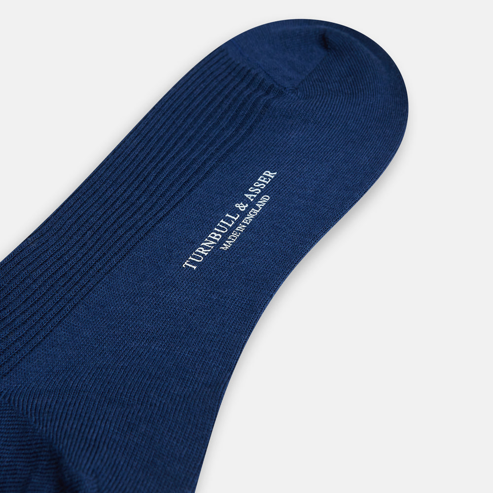 A single Turnbull & Asser Navy Mid-Length Merino Sock is shown upright against a white background, featuring a ribbed texture and smooth toe and heel for those seeking high-quality navy socks.