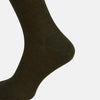 View 4 of product A Moss Green Mid-Length Merino Sock from Turnbull & Asser is shown upright on a plain white background, highlighting its ribbed texture and length with a gently curved foot.
