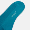 View 3 of product A Turnbull & Asser Turquoise Mid-Length Merino Sock stands upright on a plain light gray background, showcasing its ribbed texture and seamless toe.
