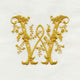 Turnbull & Asser's Embroidery features an ornate gold letter W on white fabric, adorned with intertwining floral and leaf patterns.