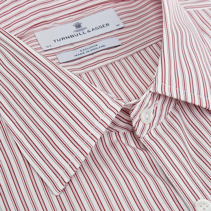 Close-up of a Turnbull & Asser dress shirt with red and white vertical stripes. The shirt features white buttons and a visible label inside the collar.