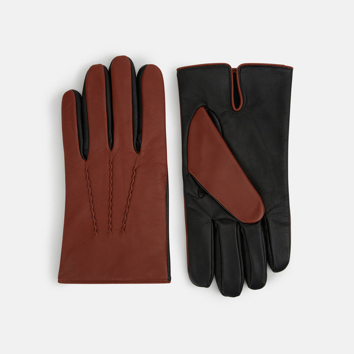 A pair of leather gloves displayed on a white background; one glove shows the brown exterior with decorative stitching, while the other shows the black palm and brown thumb.