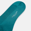 View 3 of product A single Turnbull & Asser Teal Mid-Length Merino Sock stands upright against a white background, featuring a ribbed texture and the signature elegance of luxury merino wool.