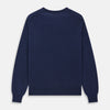 View 4 of product The Blue Crew Neck Merino Wool Jumper by Turnbull & Asser—a classic, long-sleeved staple with ribbed cuffs and hem—lies flat against a white background.