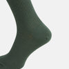 View 4 of product A single Fern Green Mid-Length Merino Sock by Turnbull & Asser, featuring a ribbed texture, is displayed on a plain white background at a slight angle to highlight its premium wool fabric, shape, and length.