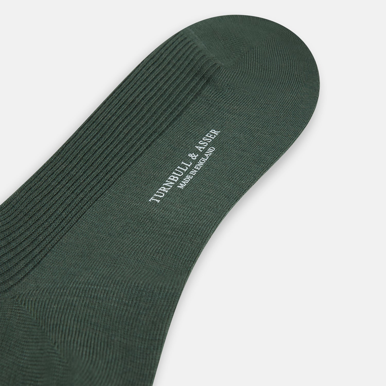 View 3 of product A single Fern Green Mid-Length Merino Sock by Turnbull & Asser, featuring a ribbed texture, is displayed on a plain white background at a slight angle to highlight its premium wool fabric, shape, and length.