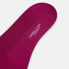 View 3 of product The Turnbull & Asser Magenta Mid-Length Merino Sock, featuring a ribbed design and crafted from soft merino wool, is displayed in a solid deep magenta color against a white background.