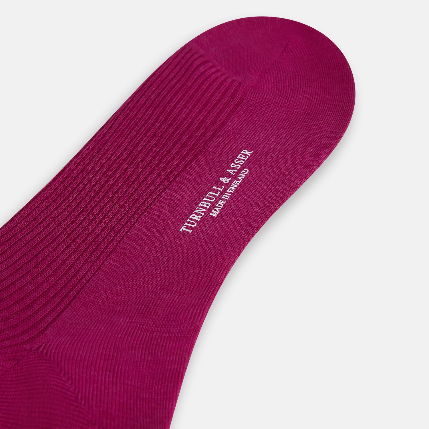 View 3 of product The Turnbull & Asser Magenta Mid-Length Merino Sock, featuring a ribbed design and crafted from soft merino wool, is displayed in a solid deep magenta color against a white background.