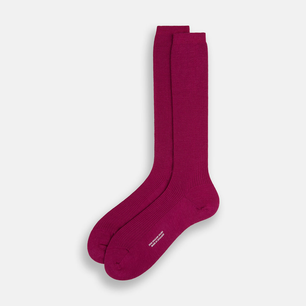 The Turnbull & Asser Magenta Mid-Length Merino Sock, featuring a ribbed design and crafted from soft merino wool, is displayed in a solid deep magenta color against a white background.