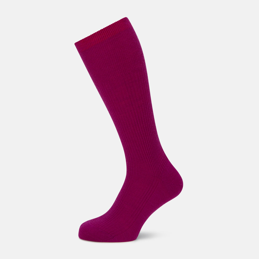 The Turnbull & Asser Magenta Mid-Length Merino Sock, featuring a ribbed design and crafted from soft merino wool, is displayed in a solid deep magenta color against a white background.